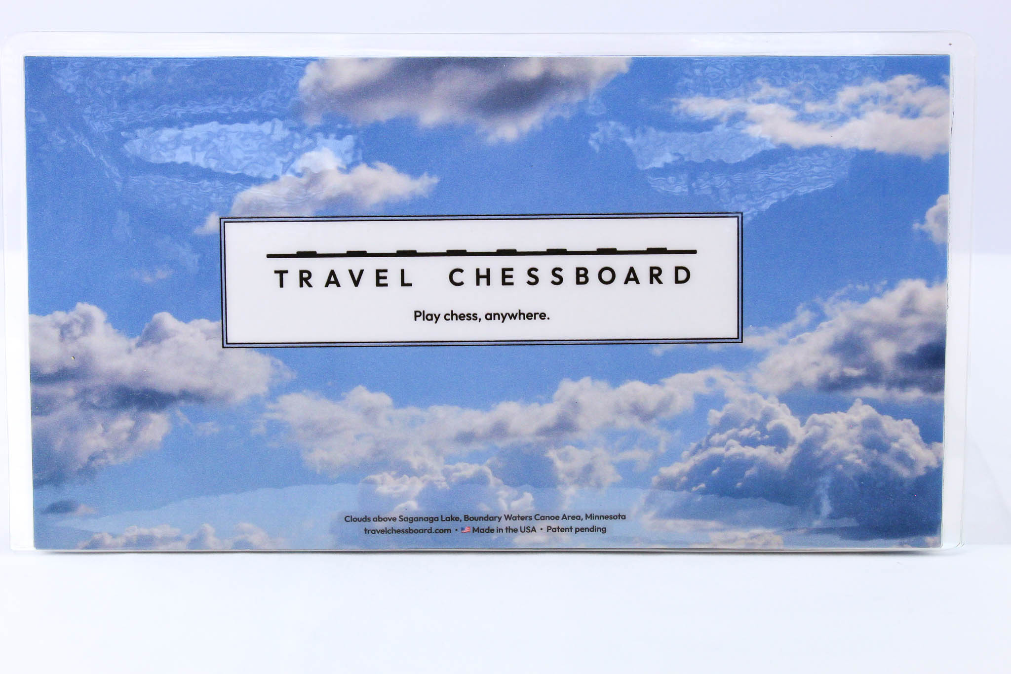 Blue Sky Travel Chessboard closed and upright on a white background straight on.