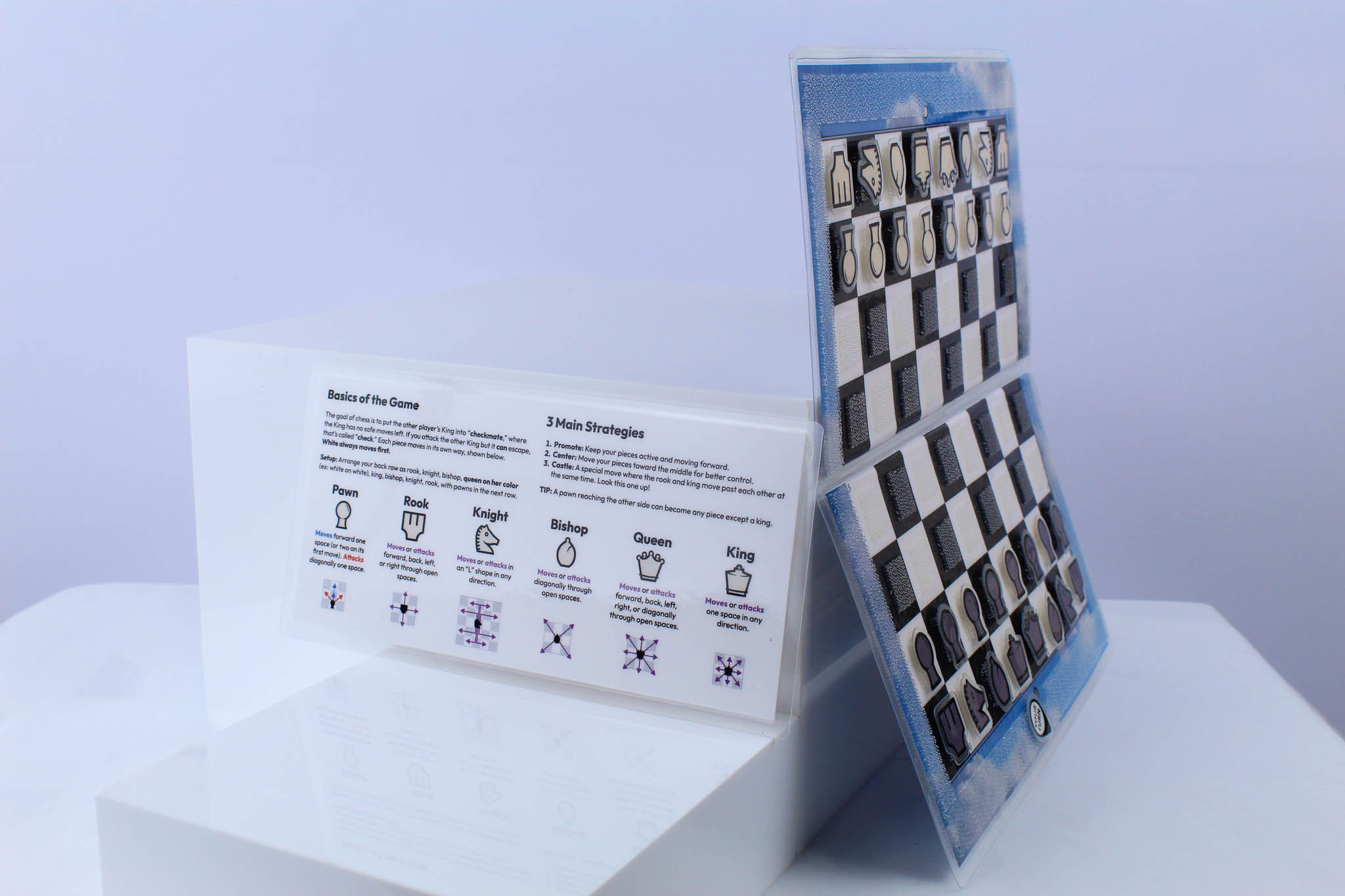 Blue Sky Travel Chessboard open and upright on a white background next to a "how to play" insert sitting up and visible.